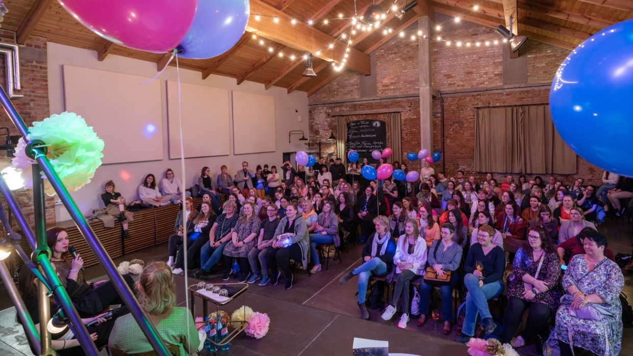 Leipzig liest Event mit Bühnentalk vor vollbesetztem Publikum in einem großen, mit Luftballons und Lichterketten geschmückten Raum während der Leipziger Buchmesse 2024